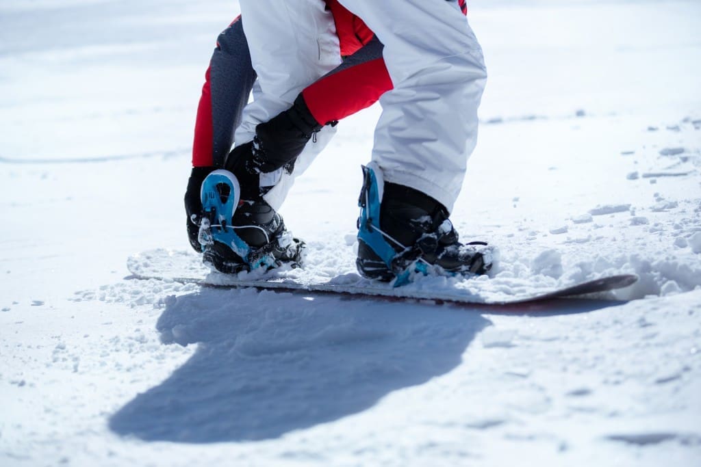 Snowboarder prepared for snowboarding, sunny day on mountains